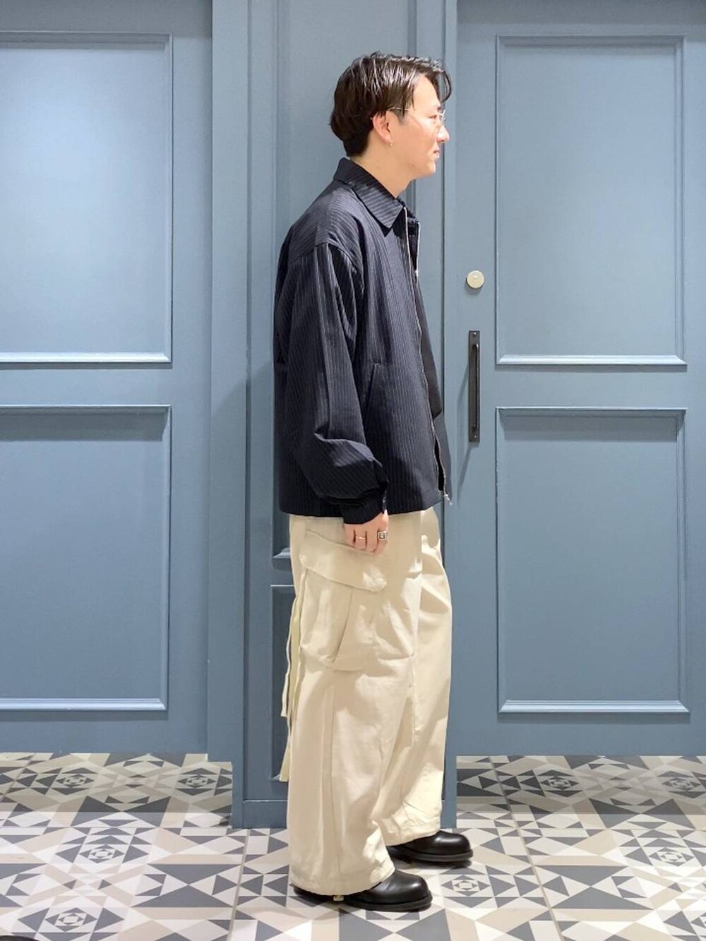 ホワイト系のカーゴパンツ、ブルー系のシャツ/ブラウス、ブラック系のTシャツ/カットソーを着用したメンズの春コーディネートの2枚目の写真