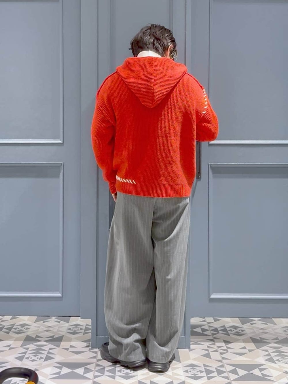 ブラック系のローファー、ホワイト系のTシャツ/カットソー、レッド系のニット/セーターを着用したメンズの冬コーディネートの3枚目の写真