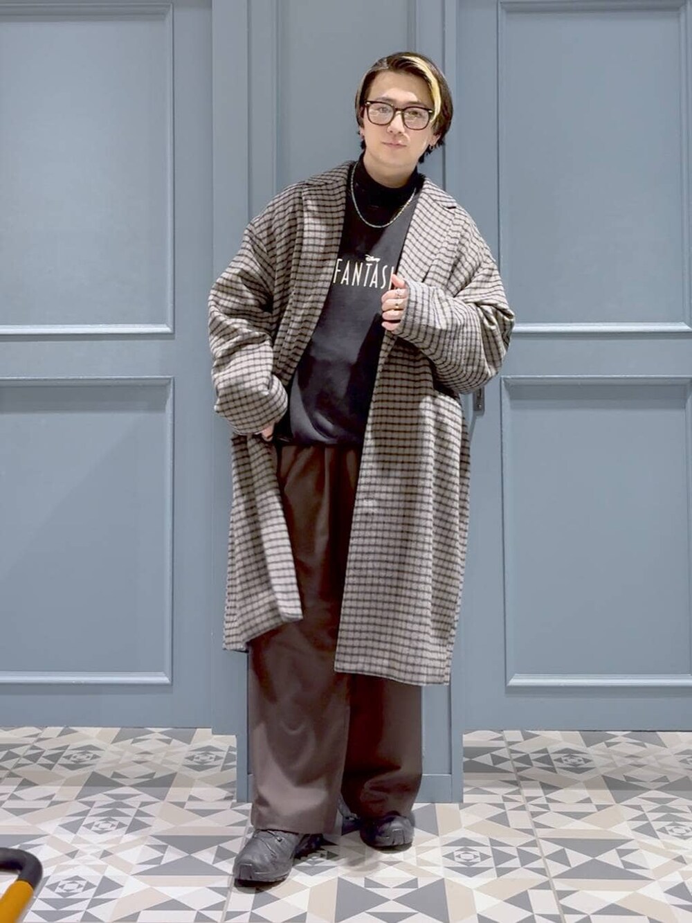 ブラック系のスニーカー、グレー系のチェスターコート、ブラック系のTシャツ/カットソーを着用したメンズの冬コーディネートの4枚目の写真