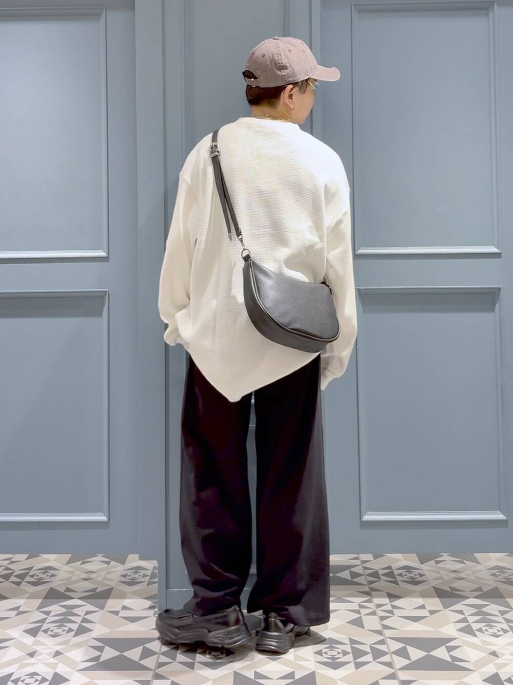 ブラック系のスウェットパンツ、ブラック系のショルダーバッグ、ブラック系のローファーを着用したメンズの秋コーディネートの3枚目の写真