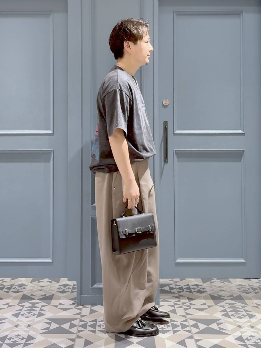 ベージュ系のスラックス、グレー系のTシャツ/カットソー、ブラック系のローファーを着用したメンズの秋コーディネートの2枚目の写真