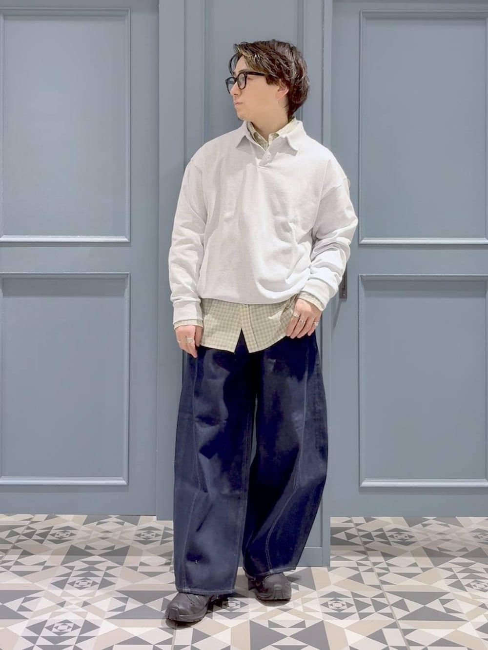 ブラック系のスニーカー、ホワイト系のシャツ/ブラウス、ブルー系のデニムパンツを着用したメンズの春コーディネートの4枚目の写真