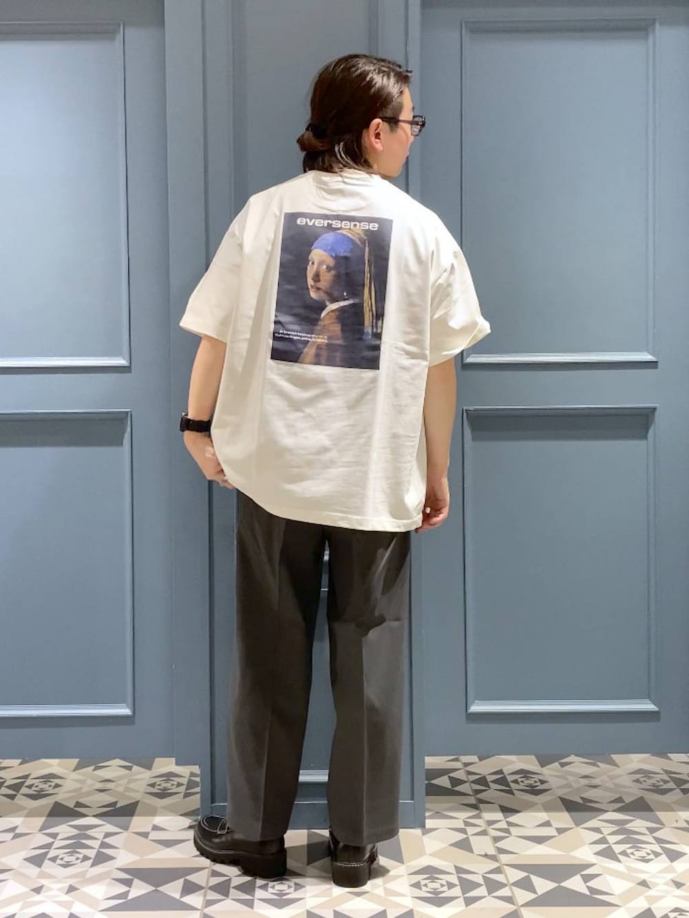 グレー系のスラックス、ブラック系のドレスシューズ、ホワイト系のTシャツ/カットソーを着用したメンズの春コーディネートの3枚目の写真