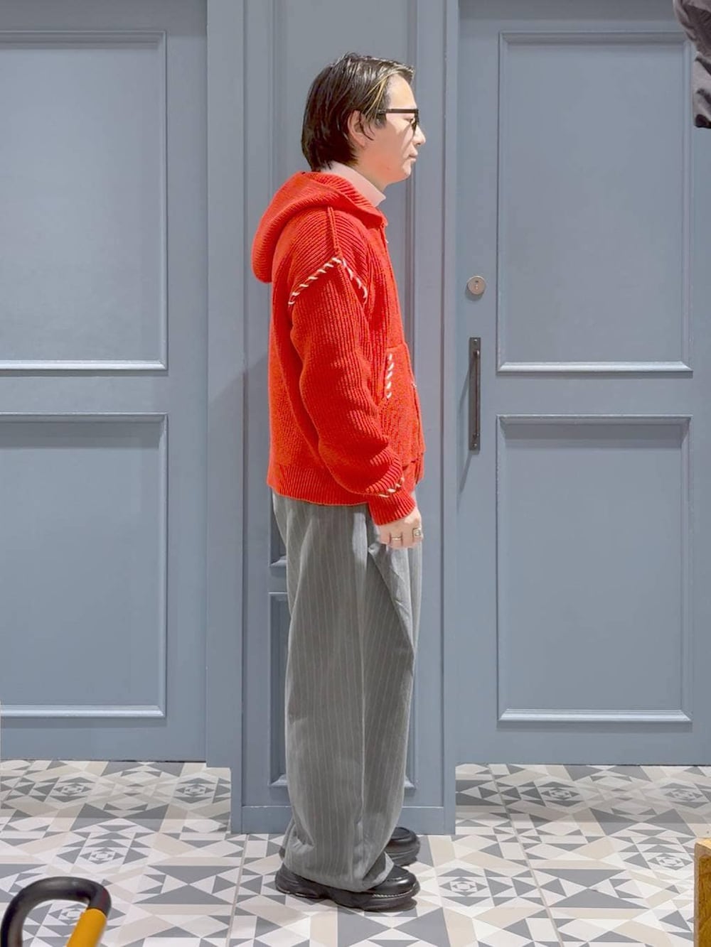 ブラック系のローファー、ホワイト系のTシャツ/カットソー、レッド系のニット/セーターを着用したメンズの冬コーディネートの2枚目の写真