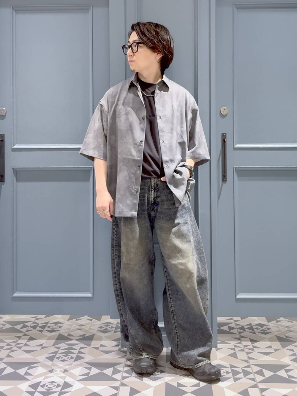 ブラック系のスニーカー、ブルー系のデニムパンツ、ブラック系のTシャツ/カットソーを着用したメンズの夏コーディネートの4枚目の写真