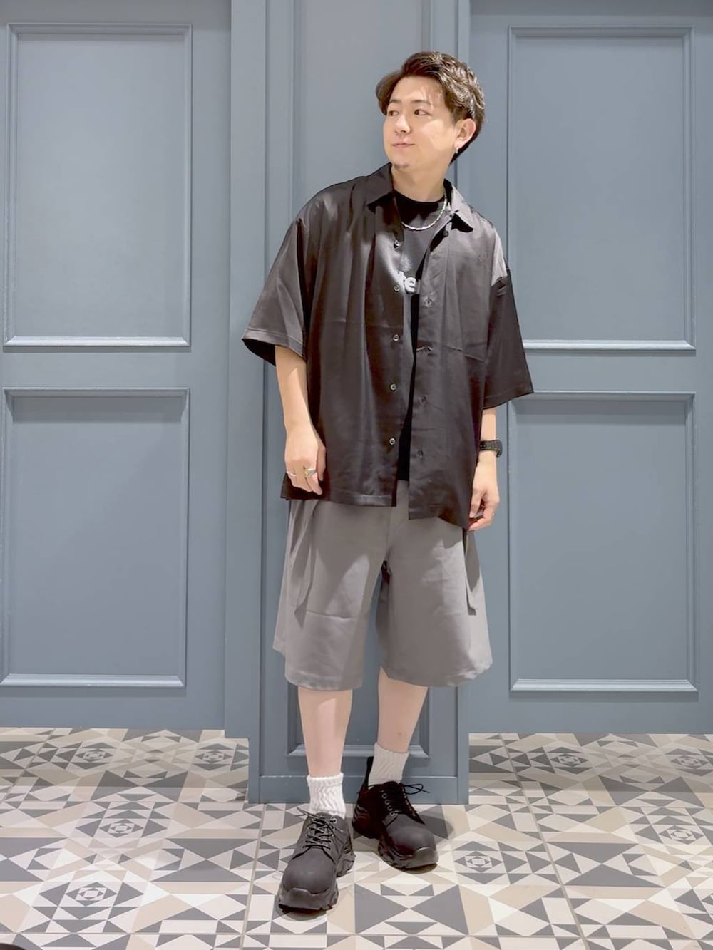 ブラック系のTシャツ/カットソー、ブラック系のシャツ/ブラウス、グレー系のスラックスを着用したメンズの夏コーディネートの4枚目の写真