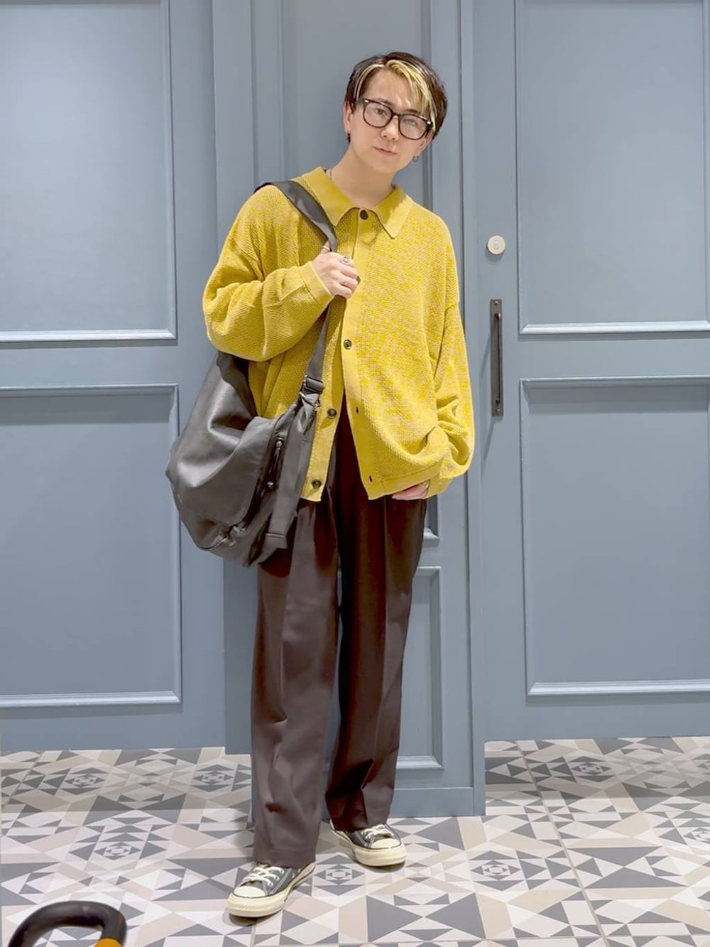 ブラック系のショルダーバッグ、ブラック系のスラックス、イエロー系のカーディガン/ボレロを着用したメンズの秋コーディネートの4枚目の写真