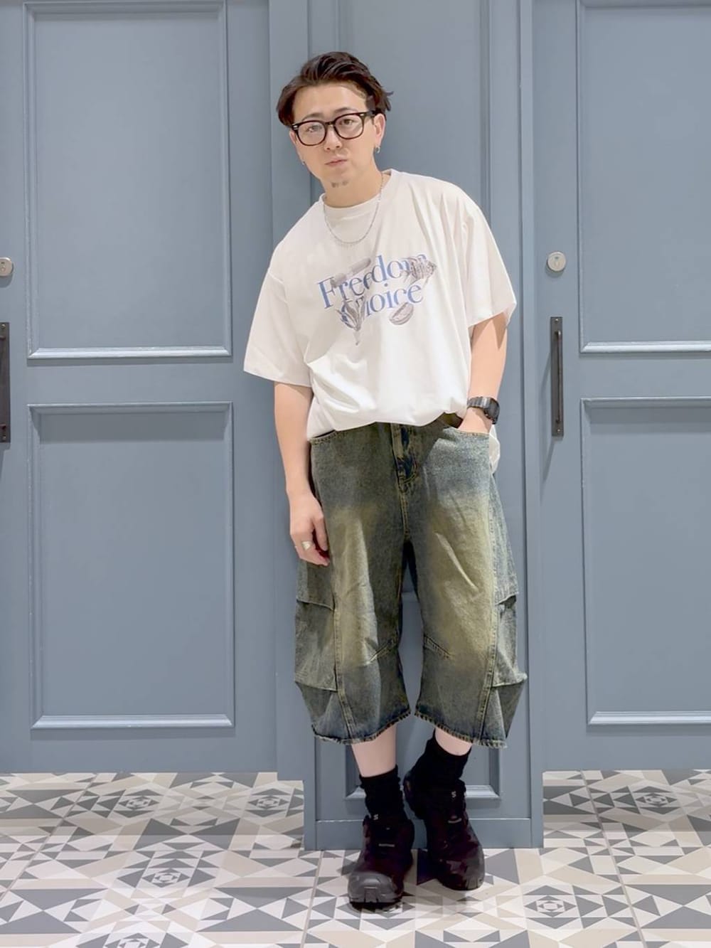 ホワイト系のTシャツ/カットソー、ブルー系のデニムパンツ、ブラック系のスニーカーを着用したメンズの秋コーディネートの4枚目の写真