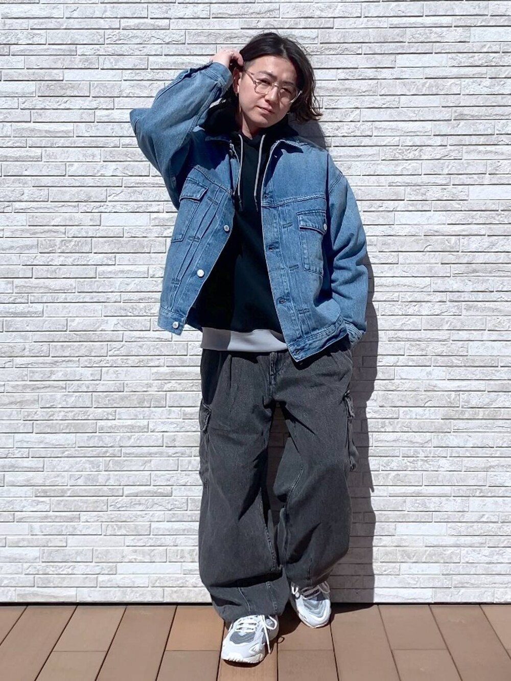 グレー系のデニムパンツ、ブルー系のデニムジャケット、ブラック系のパーカーを着用したメンズの春コーディネートの4枚目の写真