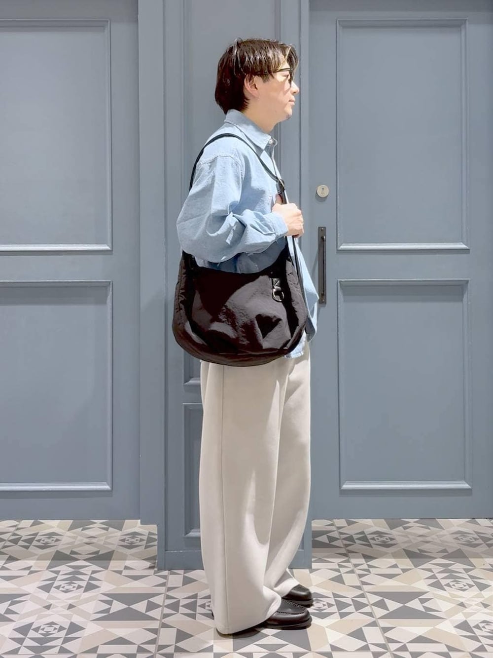 ブラック系のショルダーバッグ、ブラック系のモカシン/デッキシューズ、グレー系のその他パンツを着用したメンズの春コーディネートの2枚目の写真