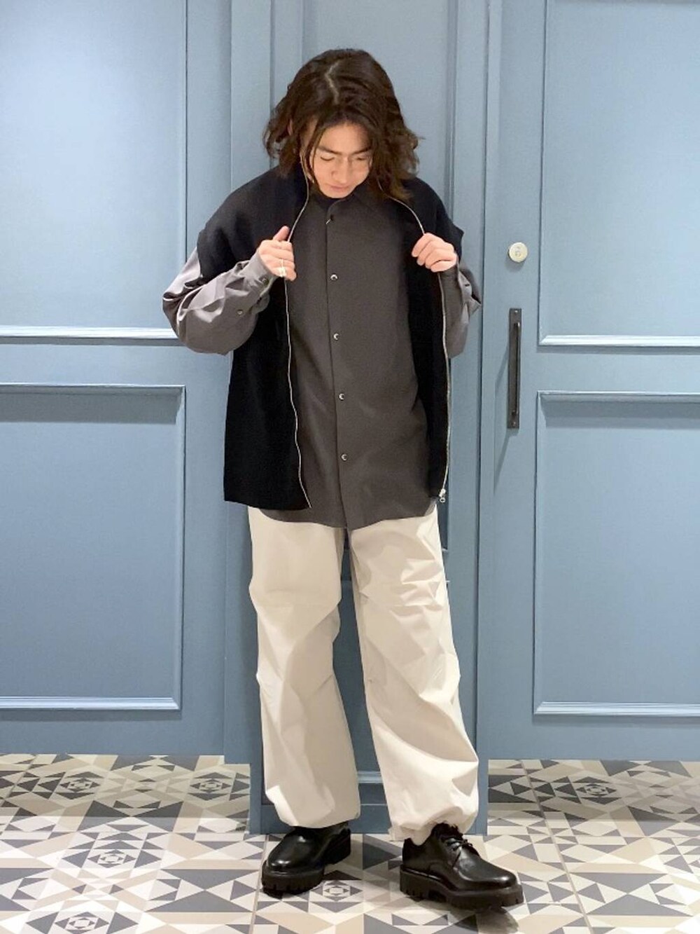 ブラック系のベスト、ブラック系のドレスシューズ、グレー系のシャツ/ブラウスを着用したメンズの春コーディネートの4枚目の写真