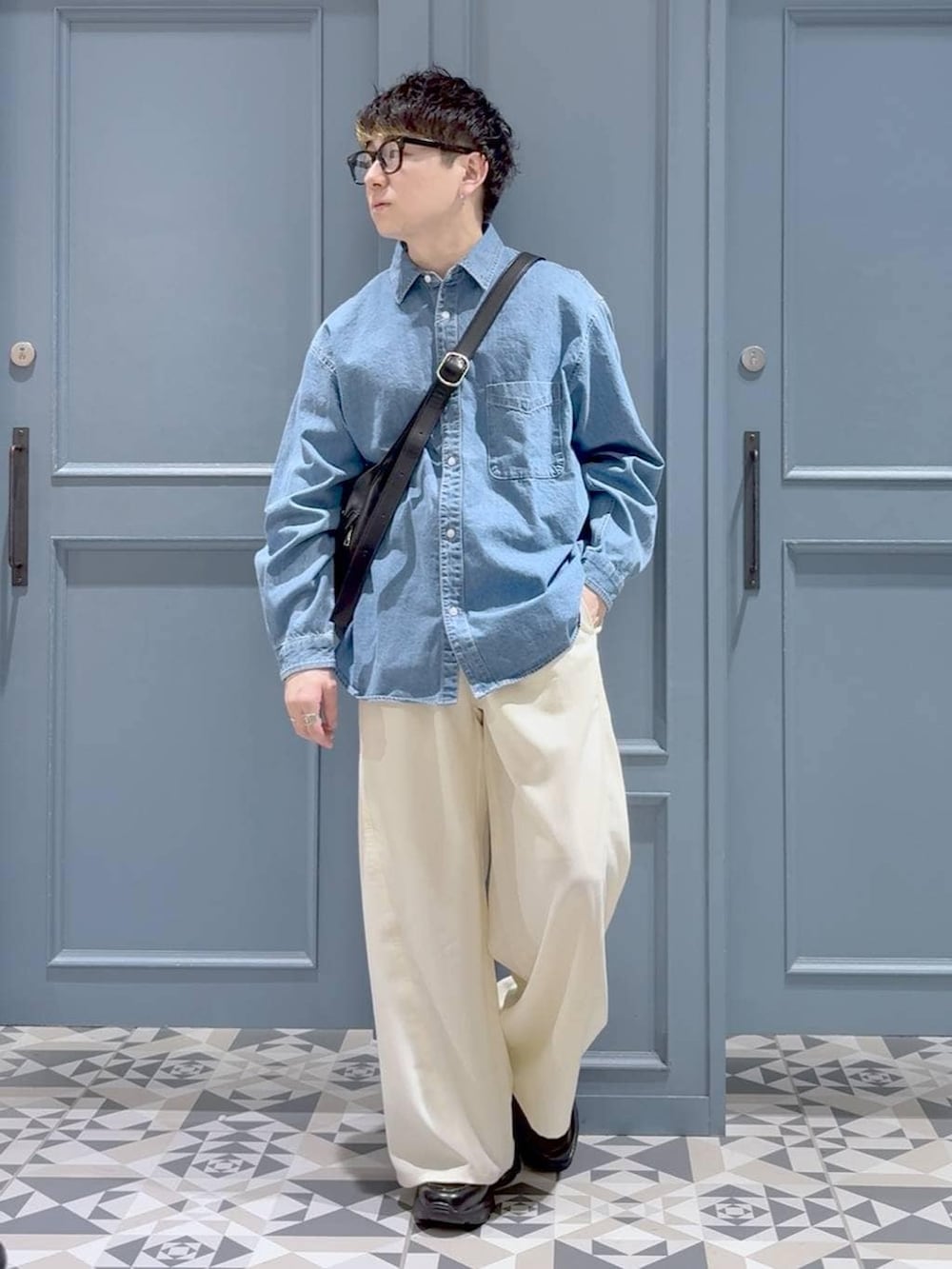 ブラック系のローファー、ブラック系のショルダーバッグ、ホワイト系のスラックスを着用したメンズの冬コーディネートの4枚目の写真