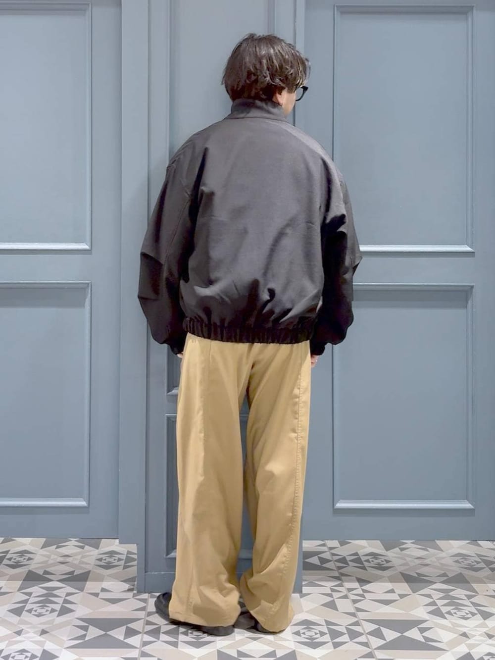 ブラック系のローファー、ブラック系のブルゾン、グレー系のポロシャツを着用したメンズの春コーディネートの3枚目の写真