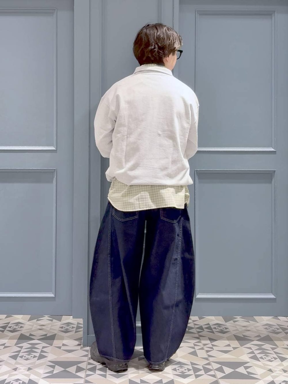 ブラック系のスニーカー、ホワイト系のシャツ/ブラウス、ブルー系のデニムパンツを着用したメンズの春コーディネートの3枚目の写真