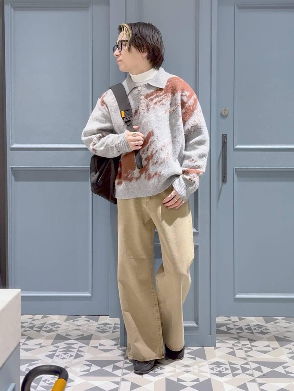 ベージュ系のデニムパンツ、ブラック系のバックパック/リュック、ホワイト系のTシャツ/カットソーを着用したメンズの冬コーディネートの4枚目の写真