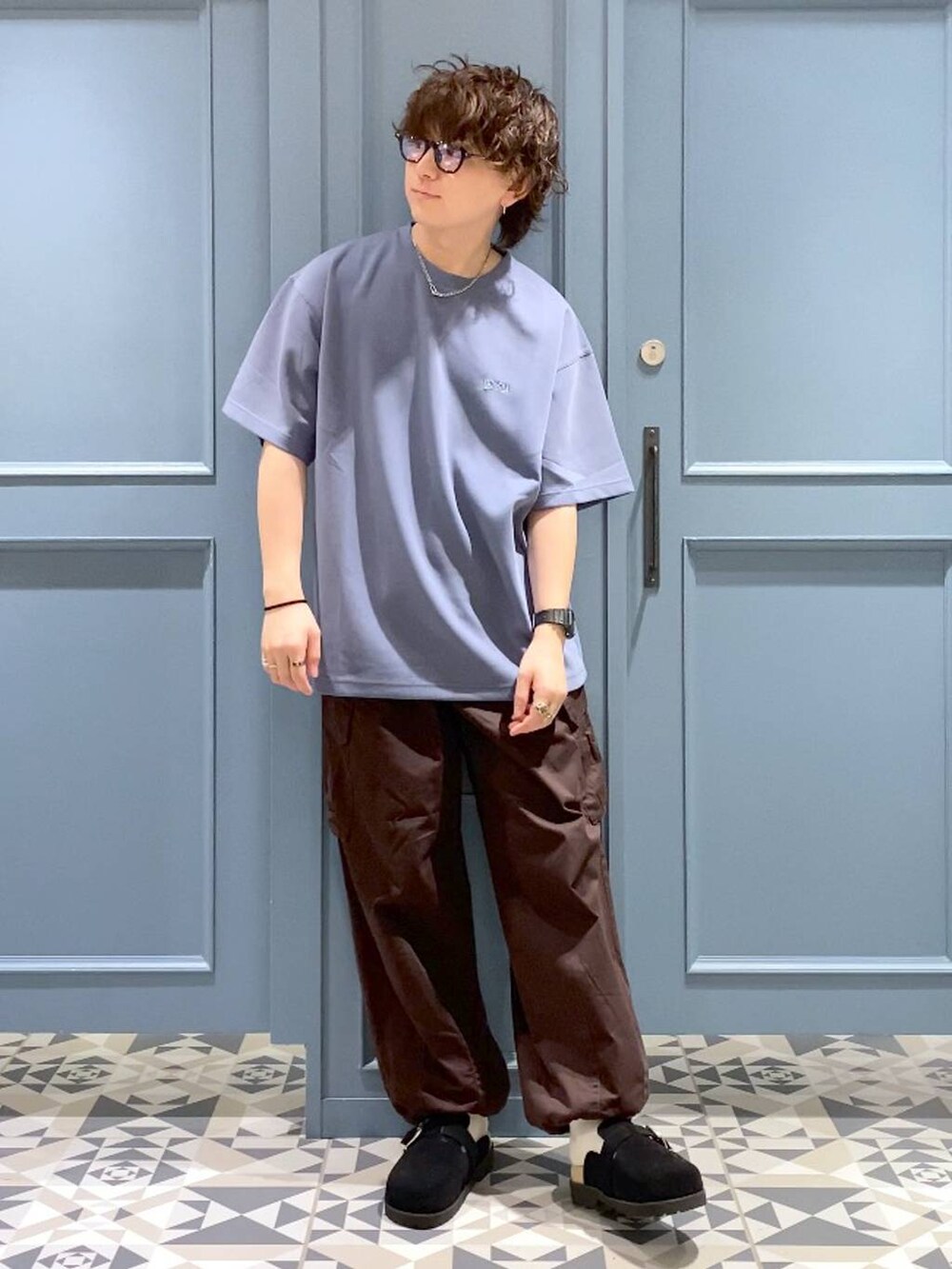 ブラウン系のカーゴパンツ、ブラック系のサンダル、ブルー系のTシャツ/カットソーを着用したメンズの夏コーディネートの4枚目の写真