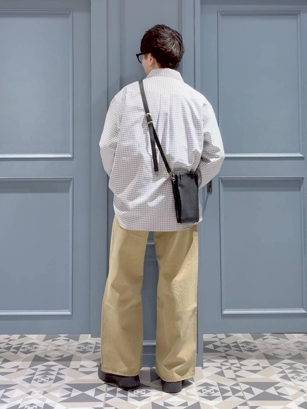 ベージュ系のデニムパンツ、ブラック系のショルダーバッグ、ブラック系のドレスシューズを着用したメンズの冬コーディネートの3枚目の写真