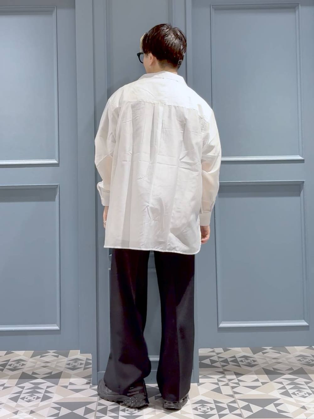 ブラック系のスニーカー、ホワイト系のシャツ/ブラウス、ブラック系のスラックスを着用したメンズの夏コーディネートの3枚目の写真