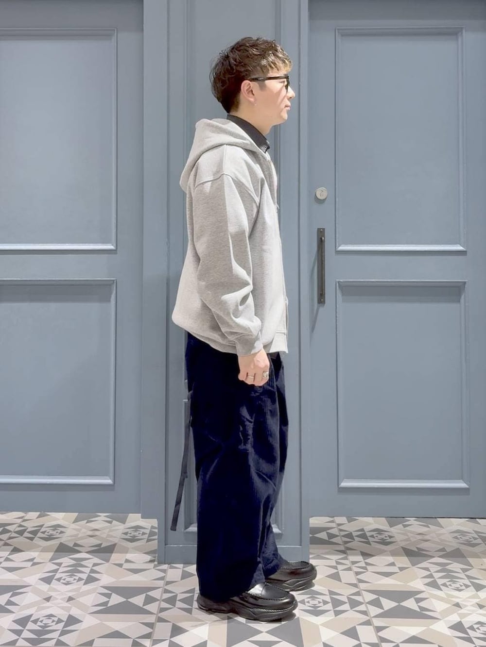 ブルー系のカーゴパンツ、ブラック系のローファー、ブラック系のシャツ/ブラウスを着用したメンズの冬コーディネートの2枚目の写真