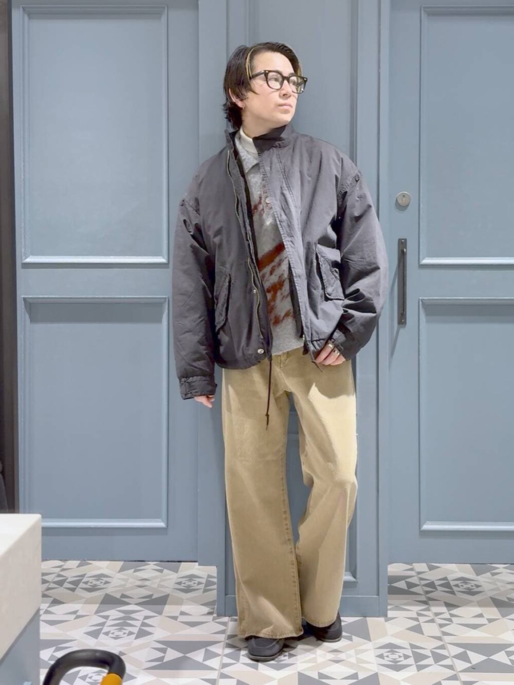 ベージュ系のデニムパンツ、グリーン系のモッズコート、グレー系のポロシャツを着用したメンズの冬コーディネートの4枚目の写真