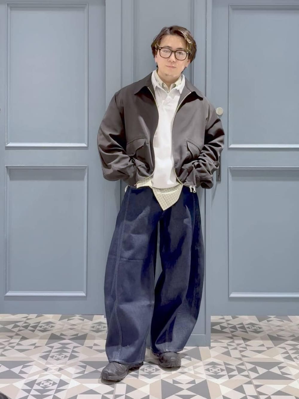 ブラック系のスニーカー、ブラック系のブルゾン、ホワイト系のシャツ/ブラウスを着用したメンズの春コーディネートの4枚目の写真