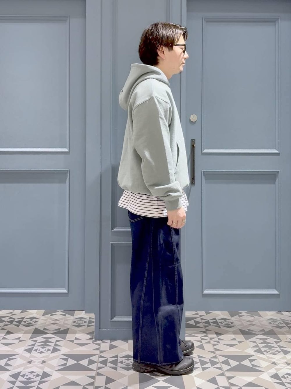 ブラック系のスニーカー、グリーン系のパーカー、ホワイト系のTシャツ/カットソーを着用したメンズの春コーディネートの2枚目の写真