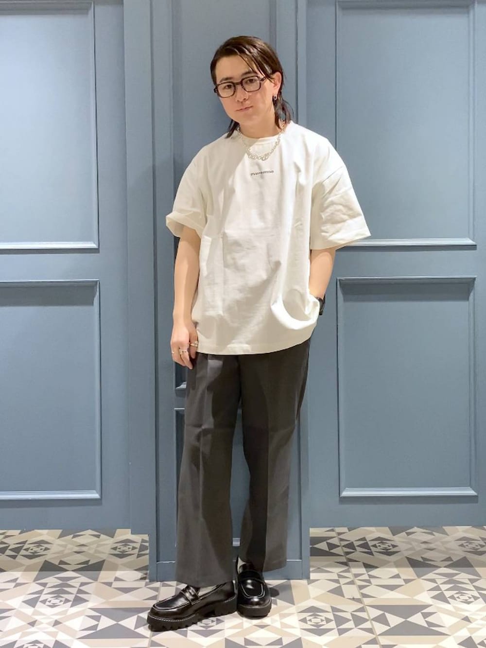 グレー系のスラックス、ブラック系のドレスシューズ、ホワイト系のTシャツ/カットソーを着用したメンズの春コーディネートの4枚目の写真