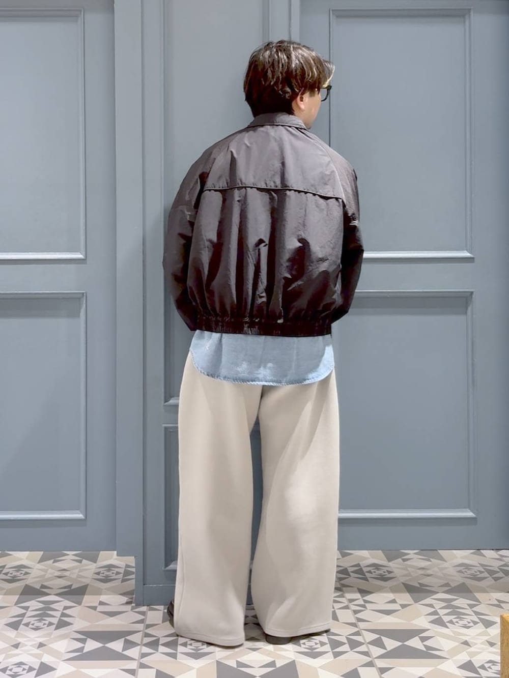 ブラック系のモカシン/デッキシューズ、ブラック系のナイロンジャケット、グレー系のその他パンツを着用したメンズの春コーディネートの3枚目の写真