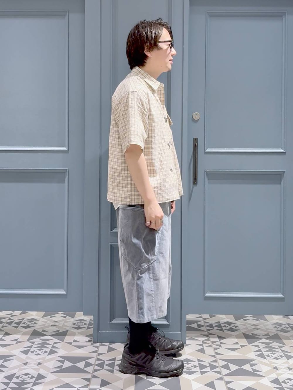 ブラック系のスニーカー、ホワイト系のTシャツ/カットソー、グレー系のデニムパンツを着用したメンズの夏コーディネートの2枚目の写真