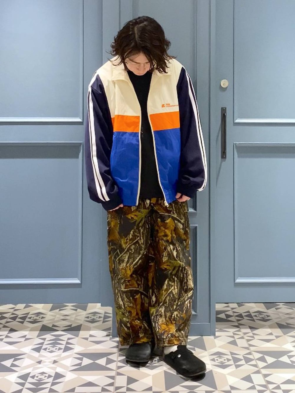 ブラック系のスウェット、ブラック系のTシャツ/カットソー、ホワイト系のブルゾンを着用したメンズの冬コーディネートの4枚目の写真