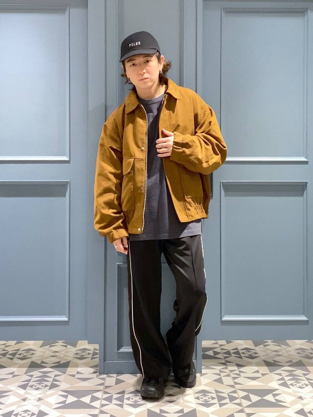 ブラック系のスニーカー、イエロー系のブルゾン、ブラック系のスウェットパンツを着用したメンズの秋コーディネートの4枚目の写真