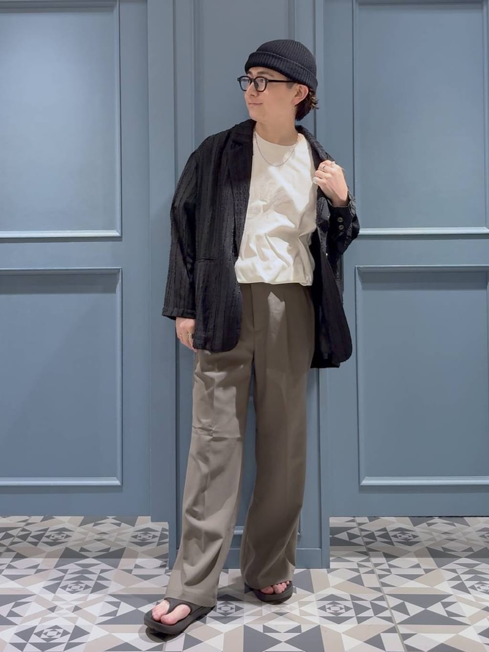 ベージュ系のスラックス、ブラック系のテーラードジャケット、ホワイト系のTシャツ/カットソーを着用したメンズの夏コーディネートの4枚目の写真