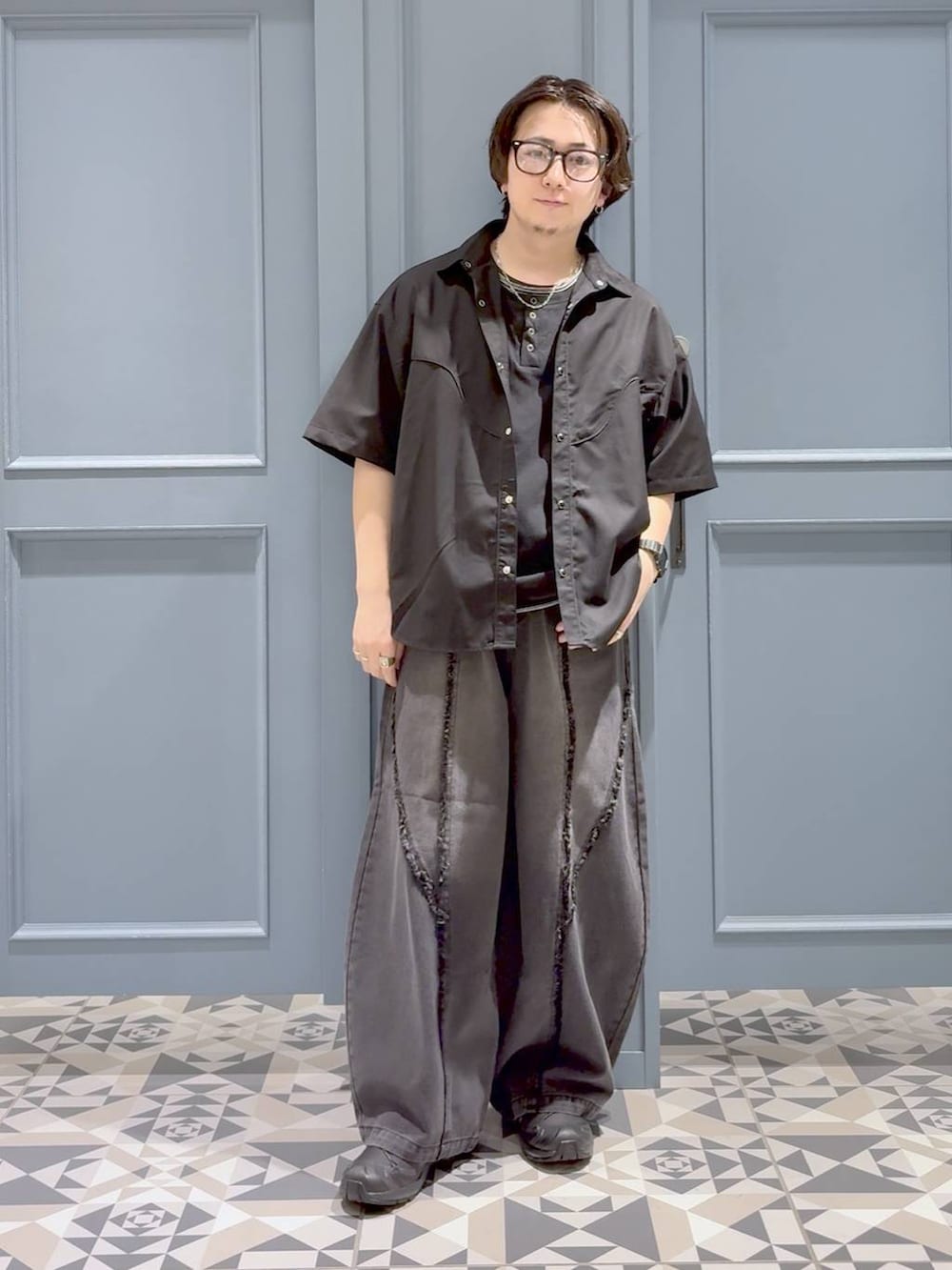 ブラック系のTシャツ/カットソー、ブラック系のデニムパンツ、ブラック系のスニーカーを着用したメンズの夏コーディネートの4枚目の写真