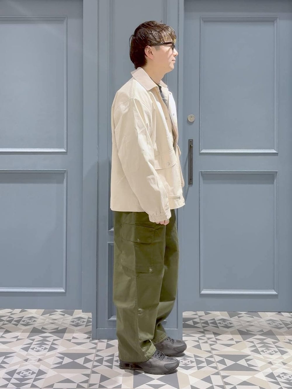 グリーン系のカーゴパンツ、ホワイト系のブルゾン、ブラック系のスウェットを着用したメンズの冬コーディネートの2枚目の写真