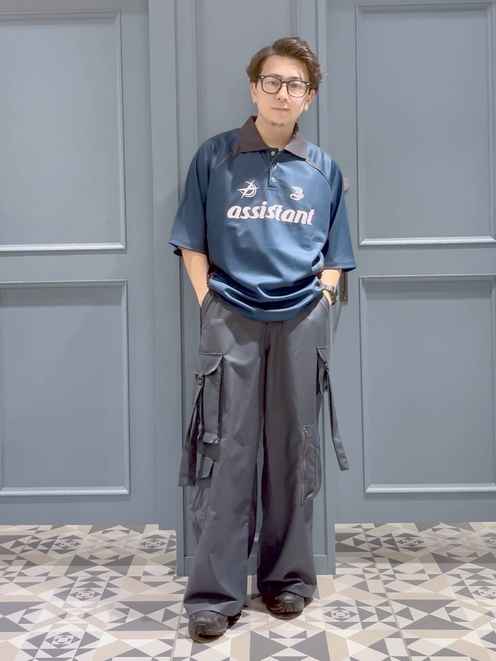 ブルー系のTシャツ/カットソー、グレー系のカーゴパンツ、ブラック系のスニーカーを着用したメンズの秋コーディネートの4枚目の写真