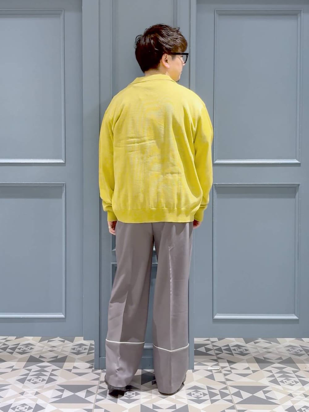 ブラック系のスニーカー、ホワイト系のTシャツ/カットソー、イエロー系のシャツ/ブラウスを着用したメンズの春コーディネートの3枚目の写真