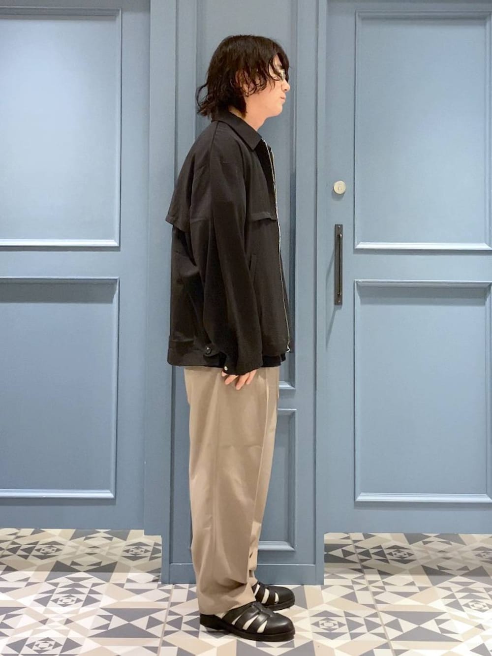 ブラック系のドレスシューズ、ブラック系のブルゾン、ブラック系のTシャツ/カットソーを着用したメンズの春コーディネートの2枚目の写真