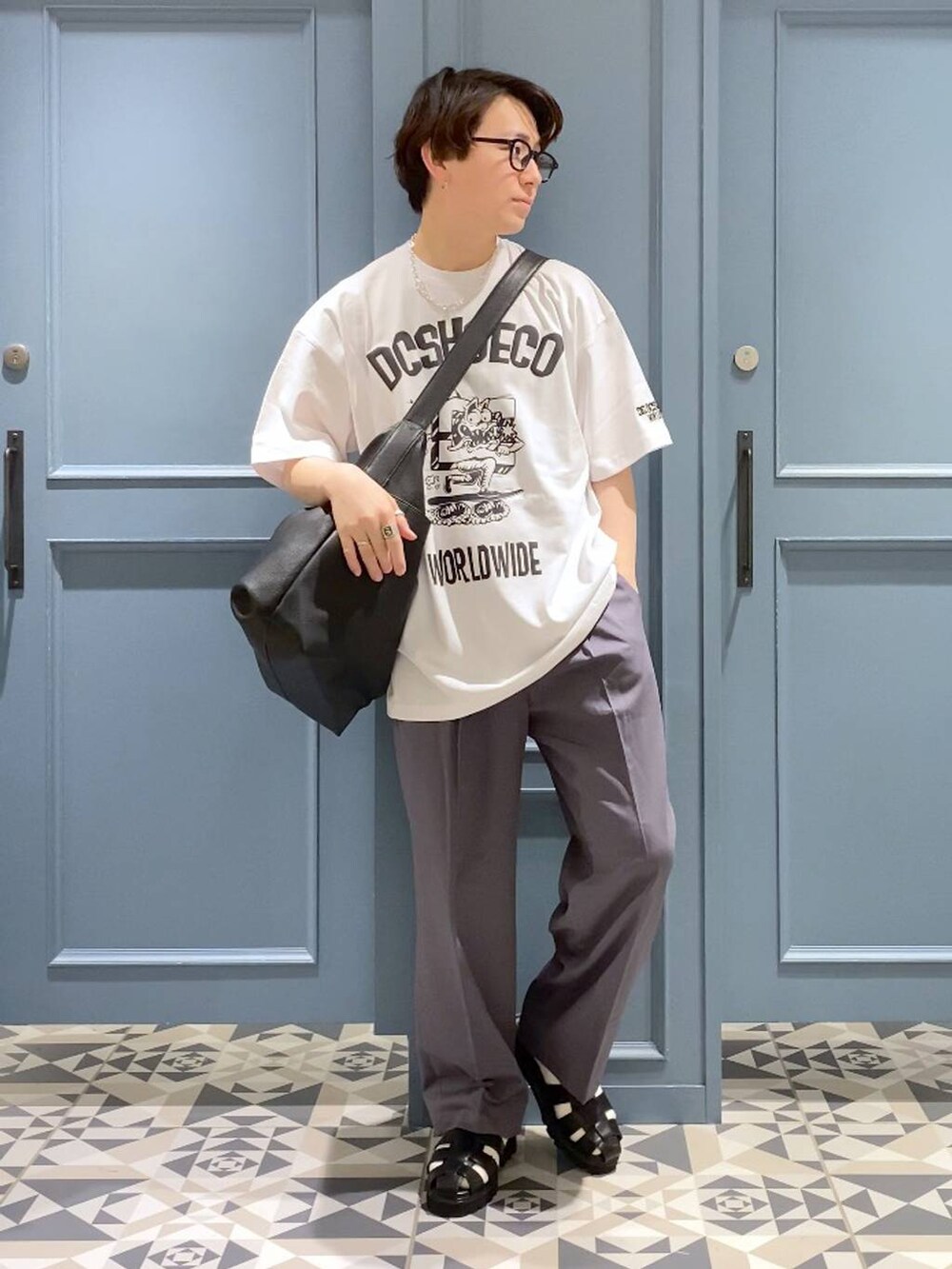 ブラック系のショルダーバッグ、グレー系のスラックス、ブラック系のサンダルを着用したメンズの春コーディネートの4枚目の写真