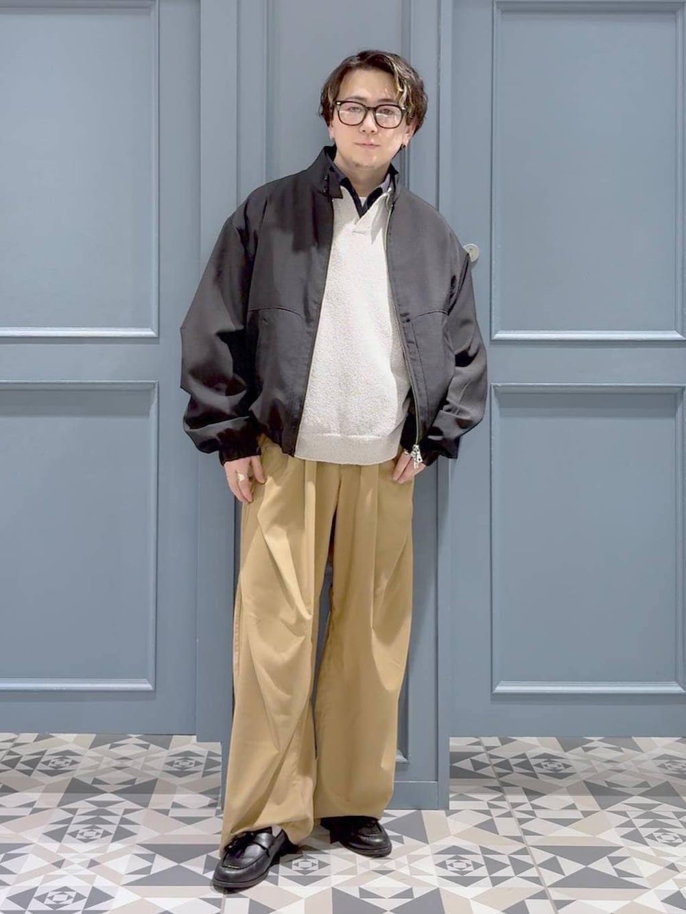 ブラック系のローファー、ブラック系のブルゾン、グレー系のポロシャツを着用したメンズの春コーディネートの4枚目の写真