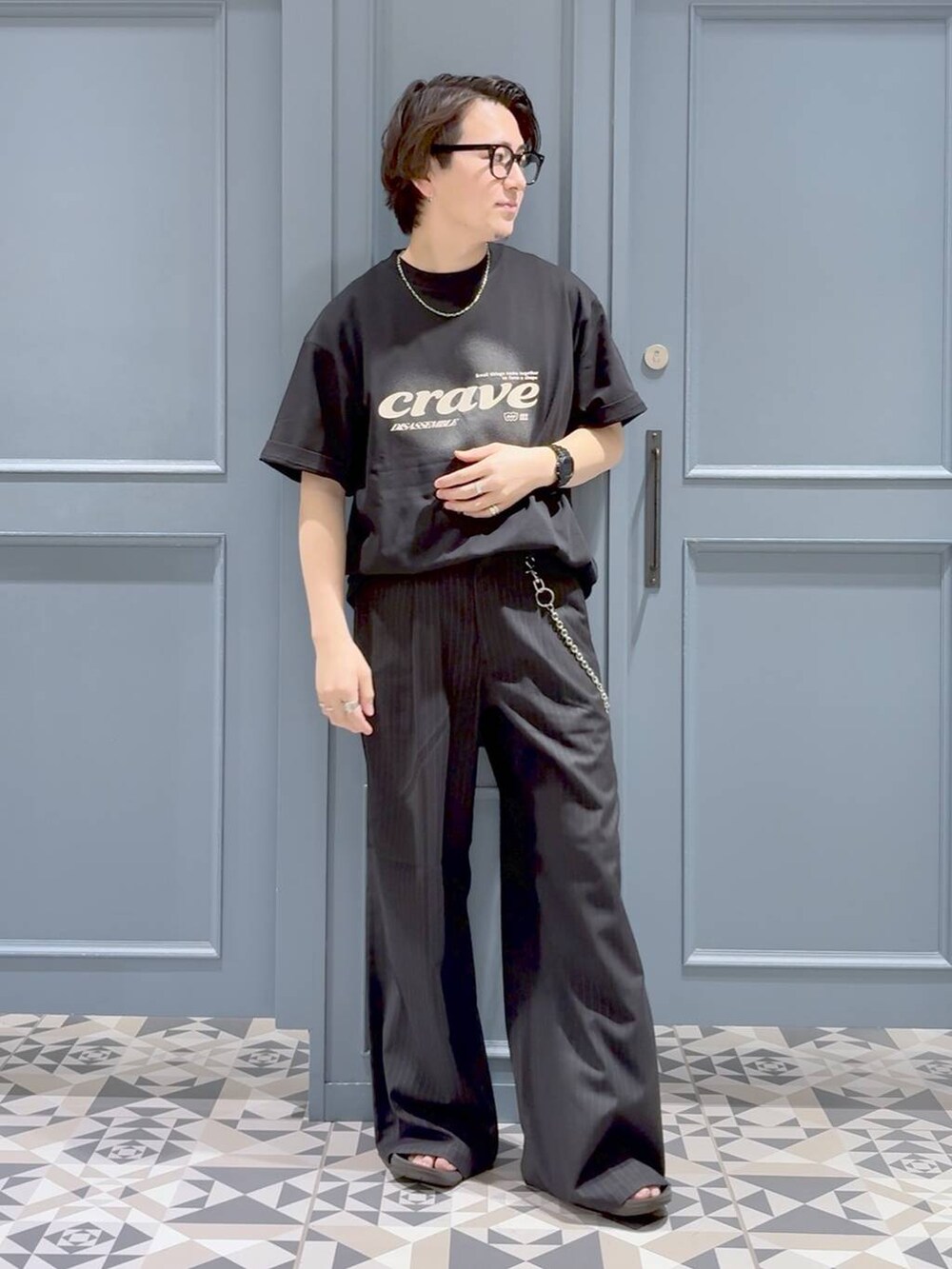 ブラック系のスラックス、ブラック系のTシャツ/カットソー、その他のネックレスを着用したメンズの夏コーディネートの4枚目の写真