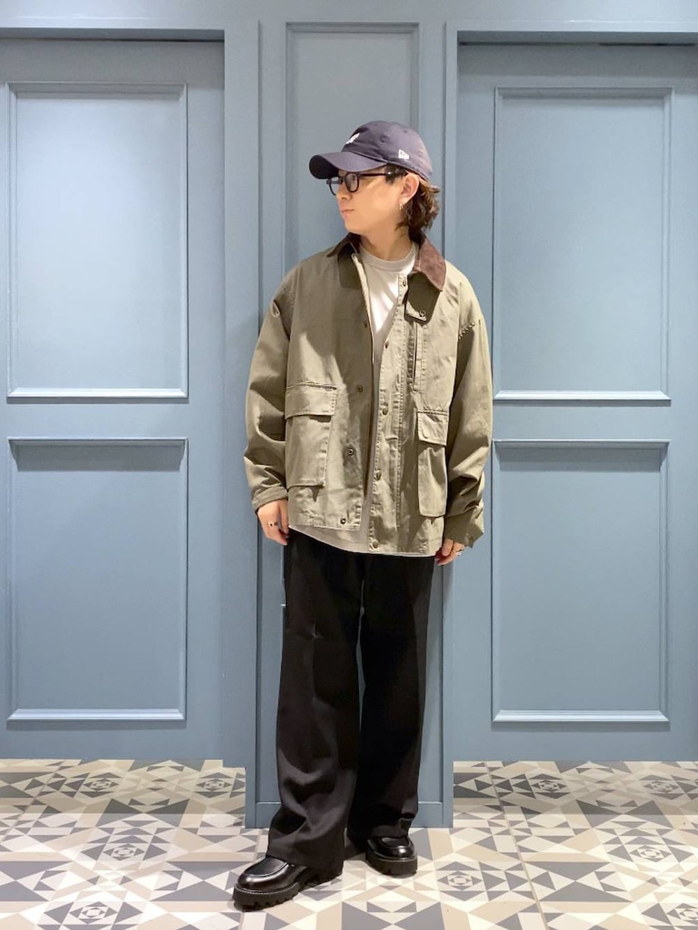 ブラック系のスラックス、グリーン系のブルゾン、ブラック系のドレスシューズを着用したメンズの秋コーディネートの4枚目の写真