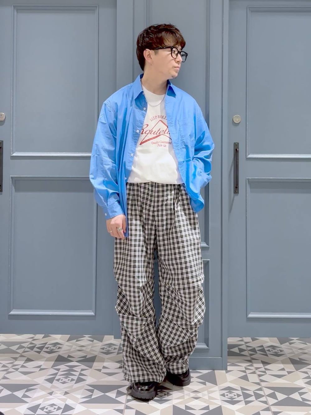 ブラック系のドレスシューズ、ブルー系のシャツ/ブラウス、ブラック系のカーゴパンツを着用したメンズの春コーディネートの4枚目の写真