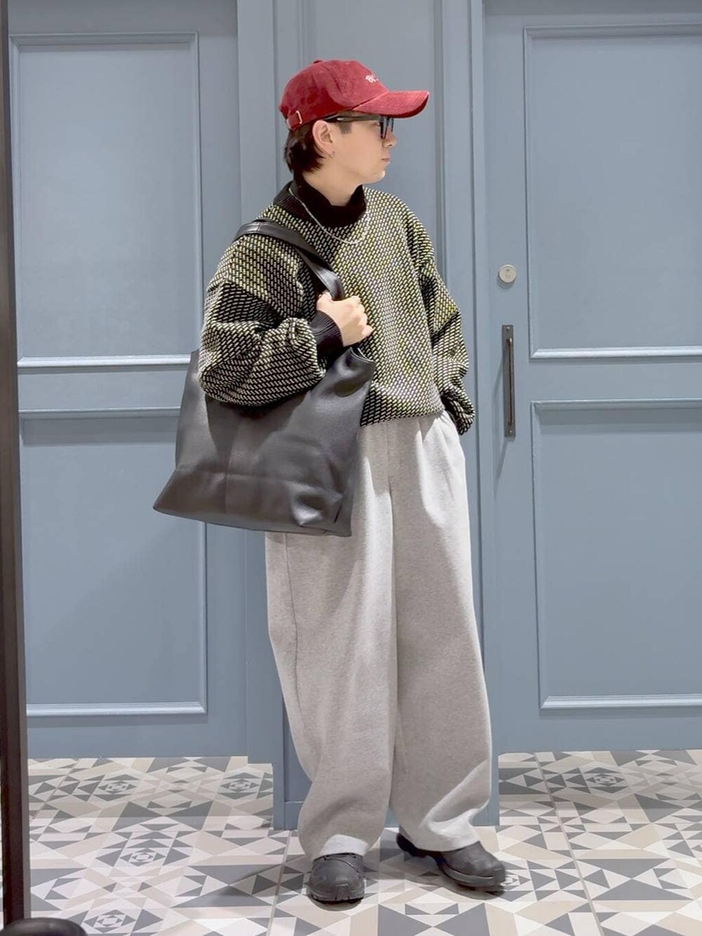 ブラック系のスニーカー、ブラック系のトートバッグ、ブラック系のTシャツ/カットソーを着用したメンズの冬コーディネートの4枚目の写真