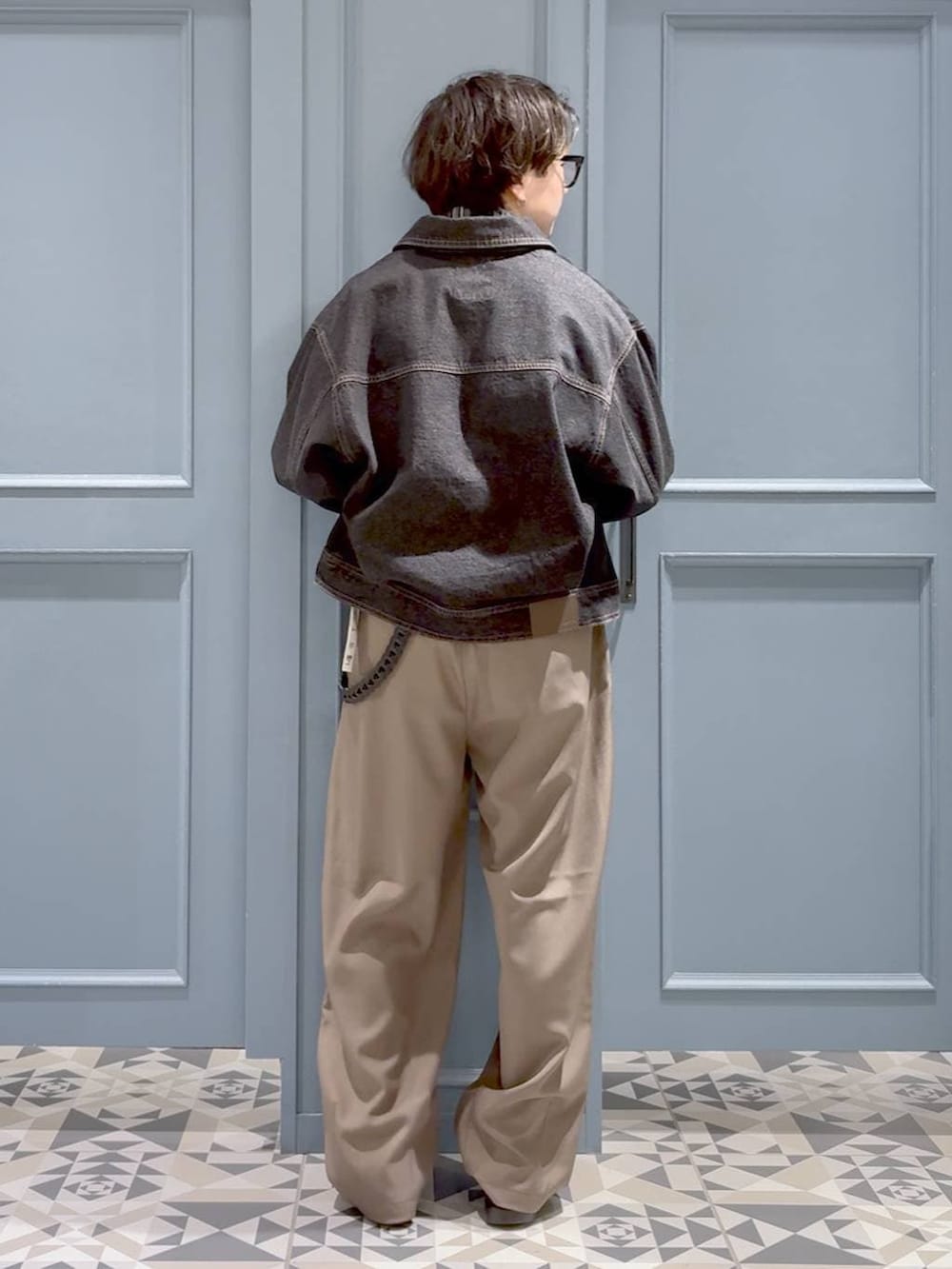 ブラック系のデニムジャケット、イエロー系のスラックス、ブラック系のブルゾンを着用したメンズの春コーディネートの3枚目の写真