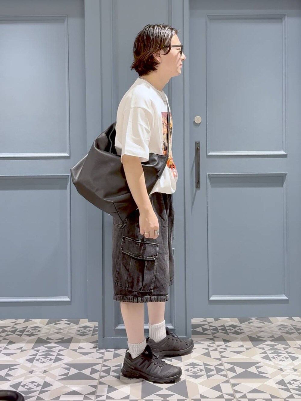 ブラック系のスニーカー、ブラック系のショルダーバッグ、ブラック系のカーゴパンツを着用したメンズの夏コーディネートの2枚目の写真