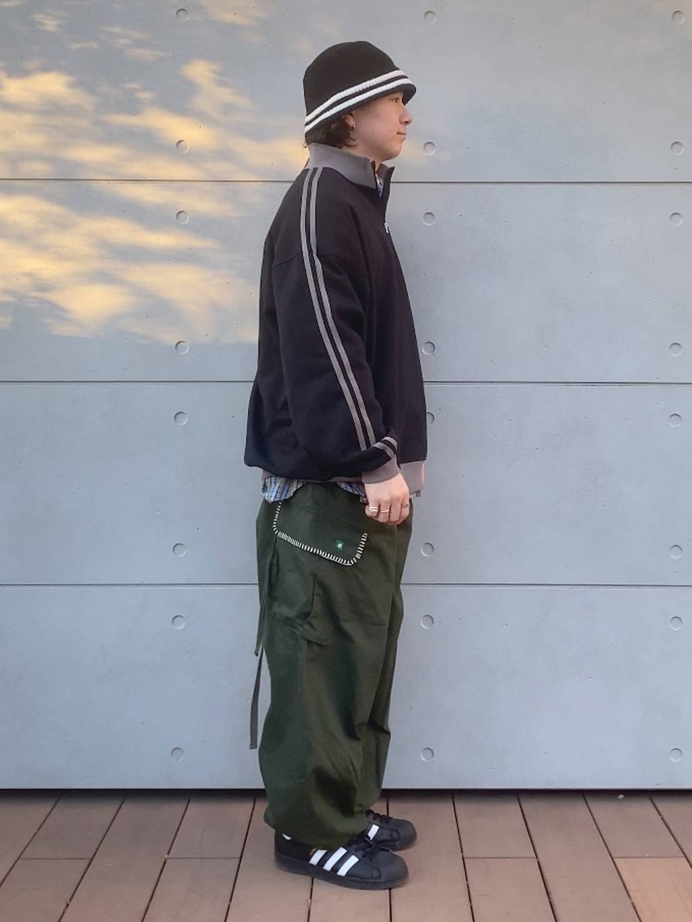 グリーン系のカーゴパンツ、ブラック系のスウェット、ブルー系のシャツ/ブラウスを着用したメンズの冬コーディネートの2枚目の写真