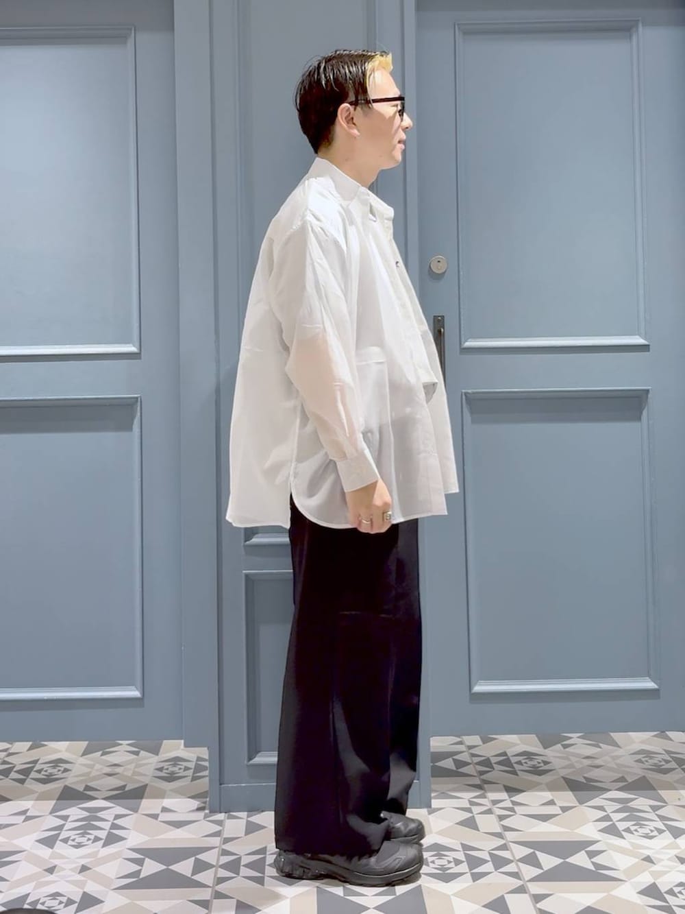 ブラック系のスニーカー、ホワイト系のシャツ/ブラウス、ブラック系のスラックスを着用したメンズの夏コーディネートの2枚目の写真