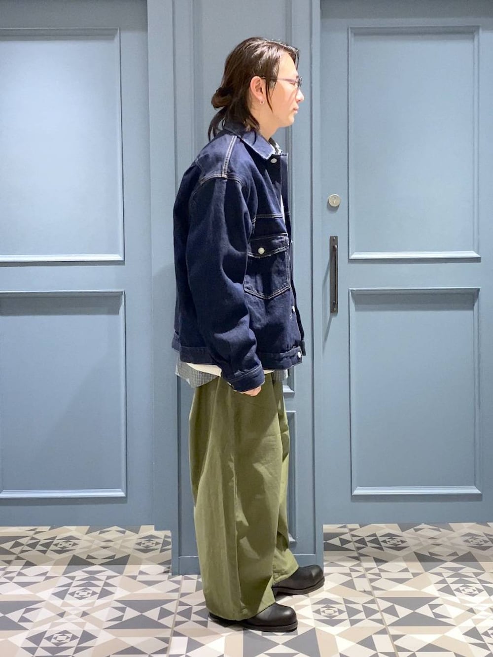 ブラック系のブーツ、グリーン系のカーゴパンツ、ブルー系のデニムジャケットを着用したメンズの春コーディネートの2枚目の写真