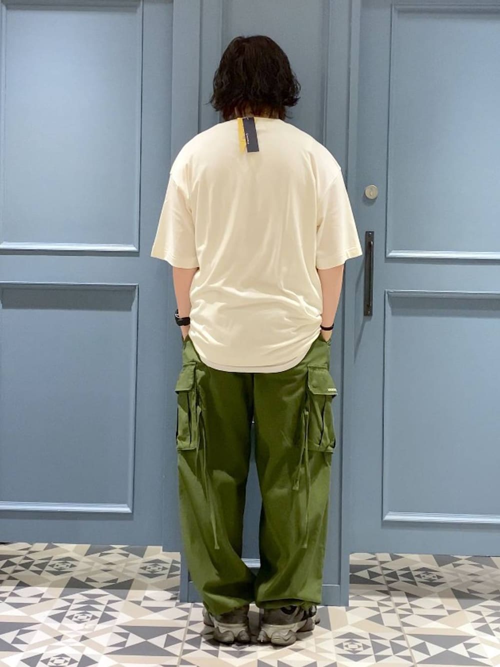 グリーン系のカーゴパンツ、ブラック系のTシャツ/カットソー、ホワイト系のネックレスを着用したメンズの春コーディネートの3枚目の写真