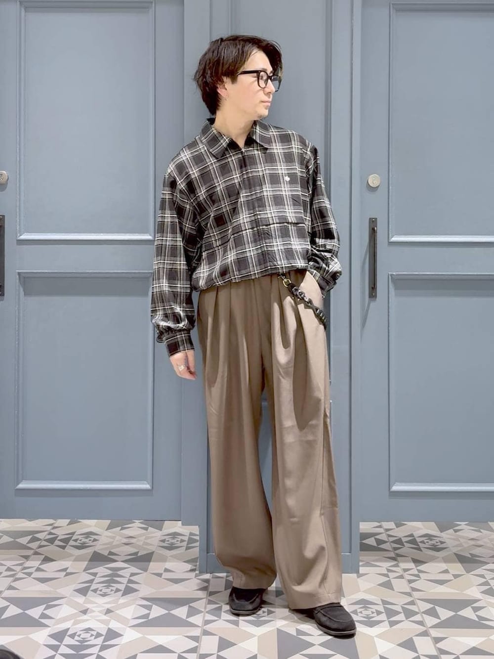 イエロー系のスラックス、ブラック系のブルゾンを着用したメンズの春コーディネートの4枚目の写真